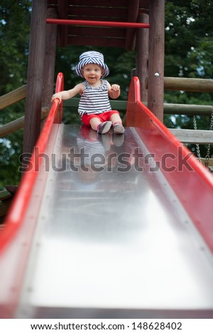 Little Girl Playing on the Slide at Park