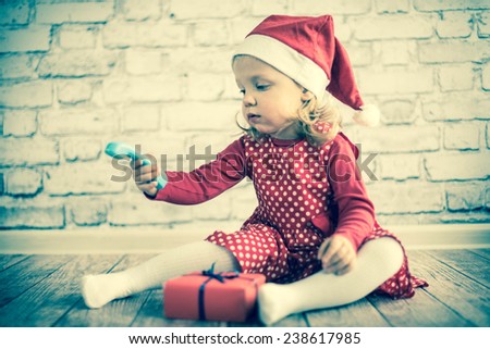 Baby in Santa\'s hat speaking with someone