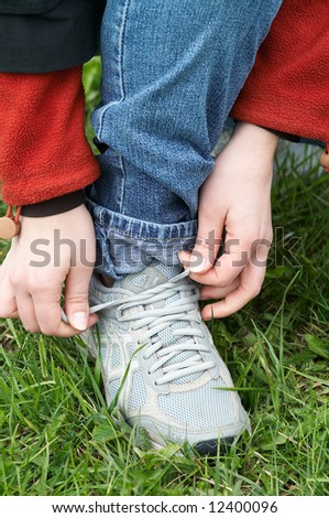 person ties shoe-laces