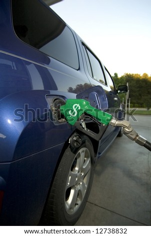 Car at gas pump with the American dollar sign on the handle