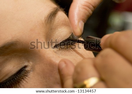 Professional make-up artist applying liner to eyes