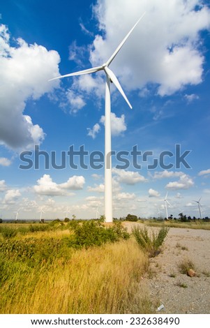 Green meadow with Wind turbines generating electricity In Thailand