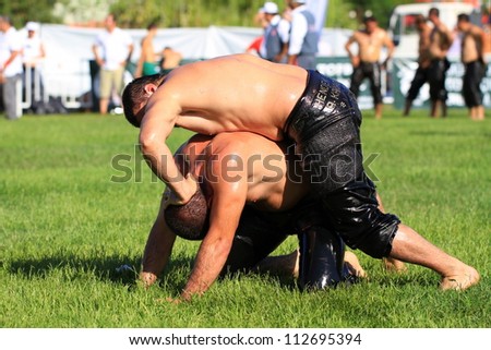 ISTANBUL - AUGUST 24: Unidentified wrestlers in the 8th Sile Annual Oil Wrestling Event on August 24, 2012 in Istanbul. Close up of oil wrestlers (Pehlivan) in a tight grip.