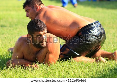 ISTANBUL - AUGUST 24: Unidentified wrestlers in the 8th Sile Annual Oil Wrestling Event on August 24, 2012 in Istanbul. Oil wrestling also called grease wrestling is a Turkish national sport.