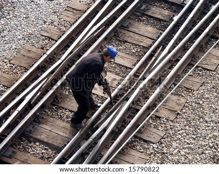 Maintenance worker fixing railway switch bolts