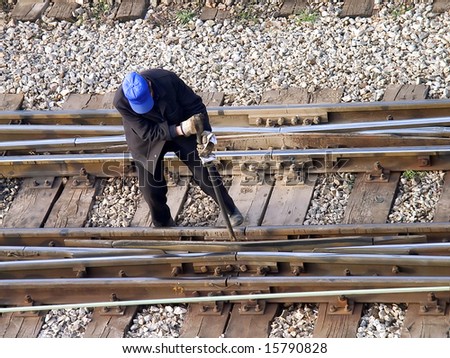 Maintenance worker fixing railway switch bolts