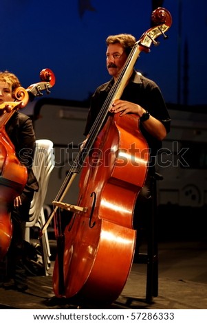 ISTANBUL - JULY 11: Members of the Maltepe Symphonic Orchestra perform live at Maltepe open air stage on July 11, 2010 in Istanbul, Musician playing contrabass.