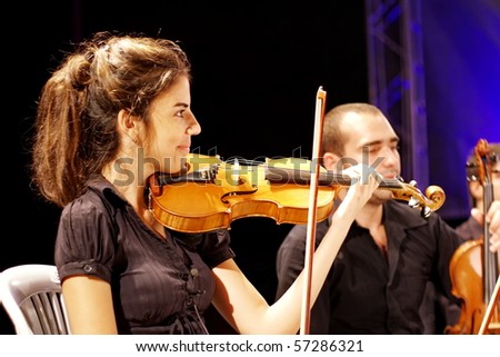 ISTANBUL - JULY 11: Members of the Maltepe Symphonic Orchestra perform live at Maltepe open air stage on July 11, 2010 in Istanbul, Musician playing violin