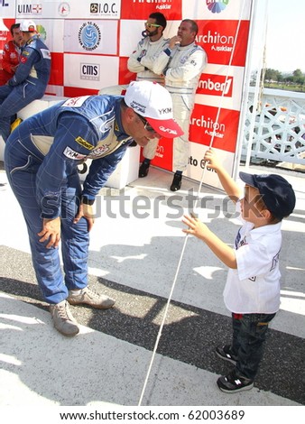ISTANBUL - SEPTEMBER 25: YKM Team member Kerim Zorlu and a child wait for the prize giving at Fatih Grand Prix during World Offshore 225 Championship, September 25, 2010 in Istanbul, TURKEY