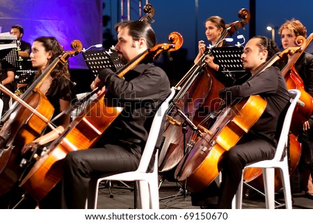 ISTANBUL - JULY 11: Members of the Maltepe Symphonic Orchestra perform live at Maltepe open air stage on July 11, 2010 in Istanbul, Musicians playing contrabass
