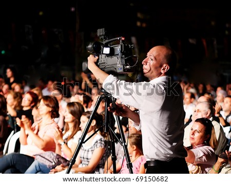ISTANBUL - JULY 11: Members of the Maltepe Symphonic Orchestra perform live at Maltepe open air stage on July 11, 2010 in Istanbul. Professional video grapher  records