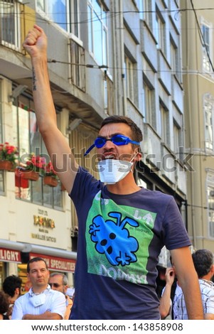 ISTANBUL - JUN 17: Labor unions call 1-day nationwide strike over crackdown on June 17, 2013 in Istanbul,Turkey. A protester makes victory sign in front of police during the protest at Istiklal Street