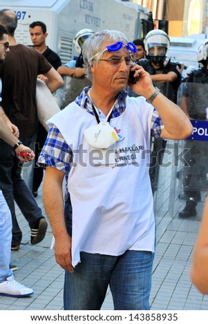 ISTANBUL - JUN 17: Labor unions call 1-day nationwide strike over crackdown on June 17, 2013 in Istanbul, Turkey. Human rights member wearing white shirt, monitors possible abuses during demonstration