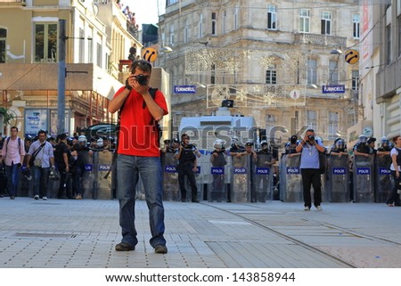 ISTANBUL - JUN 17: Five labor unions call 1-day nationwide strike over crackdown on June 17, 2013 in Istanbul, Turkey. A photographer captures the protest in front of the lined up riot police