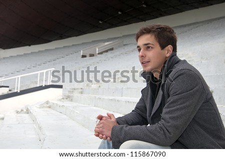 the guy sitting in the stands and looking the game