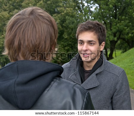 two men talking in park about something