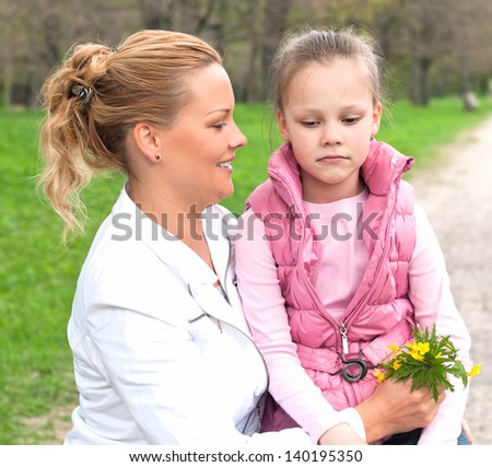 happy mother and sad daughter in the park