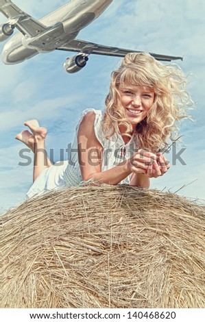 girl  in blouse lying on a haystack and smiling