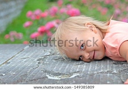 child put his head on a rock next to flower alleys