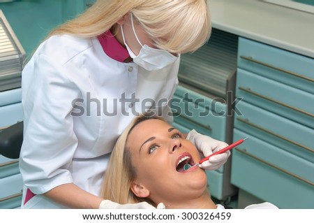 doctor checks the patient\'s teeth