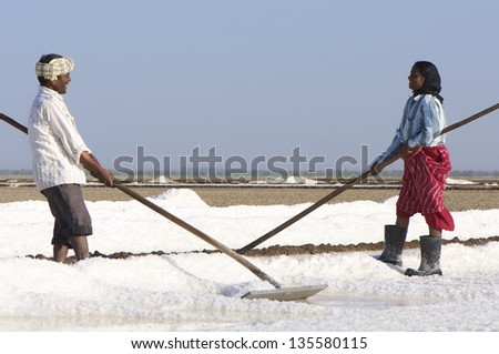DHRANGADHRA, INDIA - MARCH 13: Unidentified woman & man salt worker, Little Rann of Kutch. On March 13, 2012 in Dhrangadhra, India.  India is world\'s 3rd largest producer of salt, 80% from Gujarat.