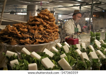 MARRAKECH, MOROCCO - MARCH 14: Unidentified man serves mint tea and pastries on March 14, 2011 in Marrakech, Morocco. Place Djemma el Fna is popular with tourists and locals, close to April 2011 bomb