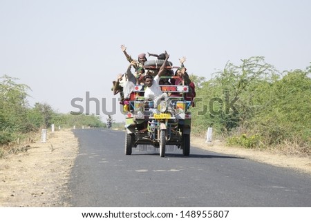 DHRANGADHRA, INDIA - MARCH 14: Unidentified travellers, mostly salt workers in the Little Rann of Kutch on March 14, 2012 near Dhrangadhra, Gujarat, India. Transport for workers is often overcrowded.