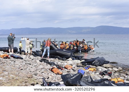 LESVOS, GREECE   SEPTEMBER 24, 2015: Refugees arriving in Greece by boat from Turkey. These Syrian refugees being filmed by reporters and journalists as their boat lands near Molyvos, Lesvos.
