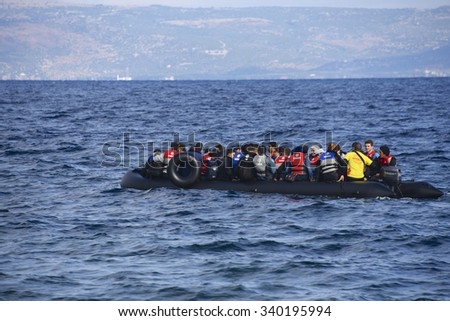 LESVOS, GREECE - SEPTEMBER 29, 2015: Refugees, escaping war and IS (ISIL), arriving in Greece by boat from Turkey. Volunteer lifeguards swam out to assist and guide the boat in when the motor failed.