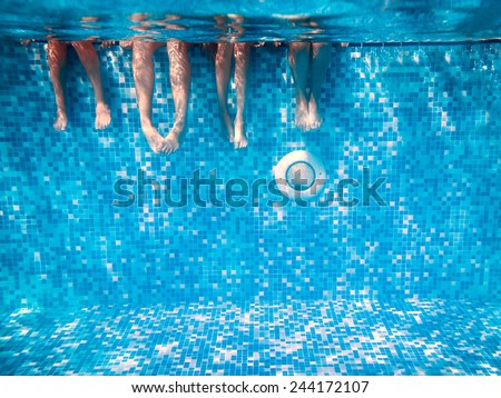 Children\'s and adults legs underwater