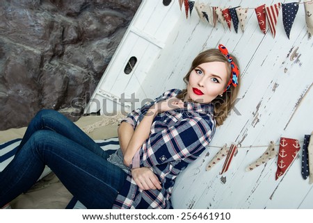 Beautiful young woman in pin-up style on sea background indoor