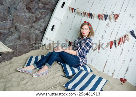 Beautiful young woman in pin-up style on sea background indoor
