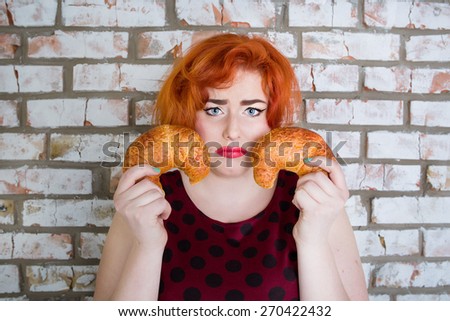 sad Red-haired girl in pin-up style with bread