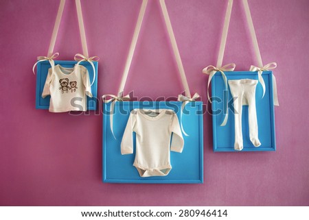 Children\'s clothing in a frames on the wall