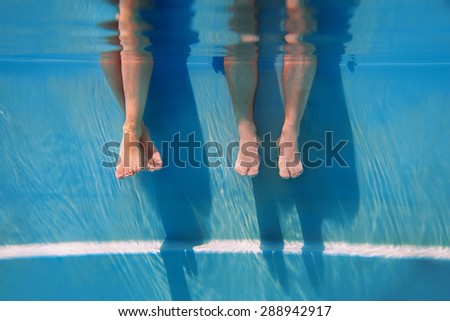 adults legs underwater in the swimming pool