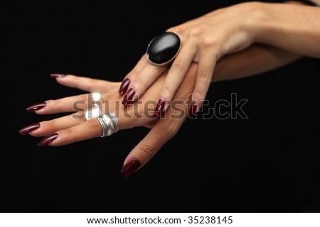 Woman\'s hands with silver rings and red nails