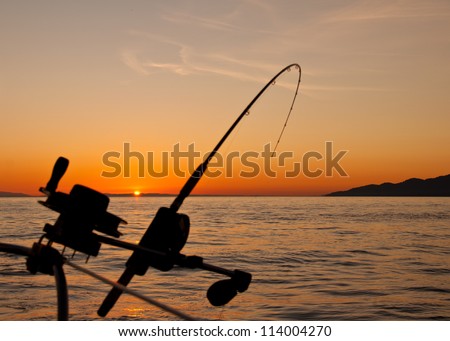 Taken just off the coast of Vancouver Island the silhouette of a down rigging fishing rod at sunset.