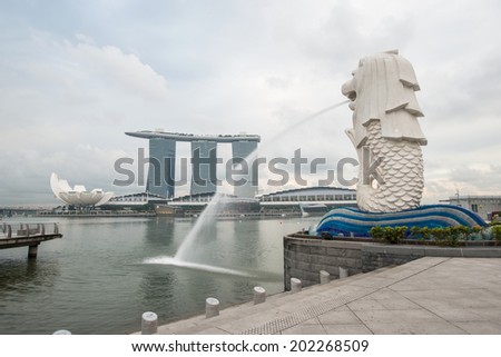 SINGAPORE - May 10: The Merlion fountain in front of the Marina Bay Sands hotel on May 10, 2014 in Singapore. Merlion is a imaginary creature with the head of a lion, seen as a symbol of Singapore