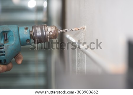 hands hold electric drill in room , interior design and home renovatio