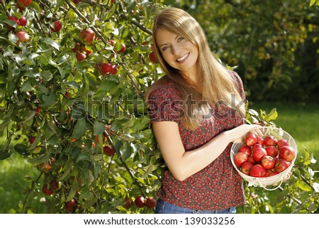 Young woman beside an apple tree