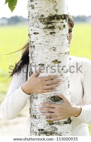 Hands hug a birch tree