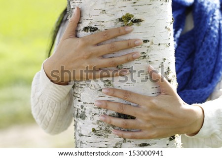 Hands hug a birch tree