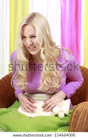 Woman holding hot bottle to cure abdominal pain