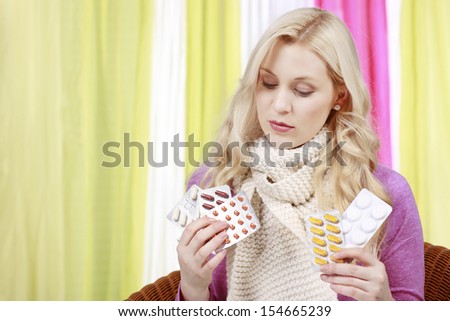 Woman with scarf decides between different pills