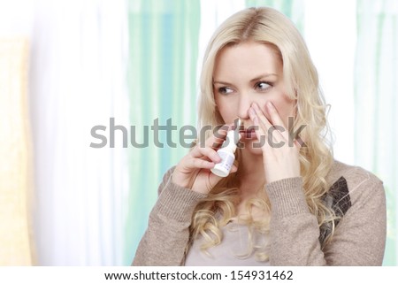 woman applies nose spray
