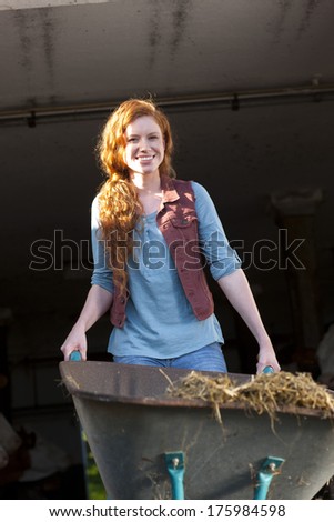 Attractive farm woman with a wheel barrow