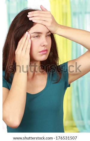 Woman suffering from migraine and hands on her forehead