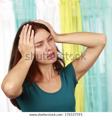 Woman suffering from migraine and hands on her forehead