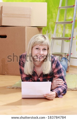 Happy woman with rental contract in front of moving boxes