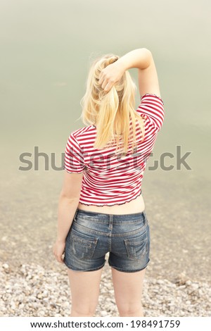 Attractive blond woman from the back looking at the water